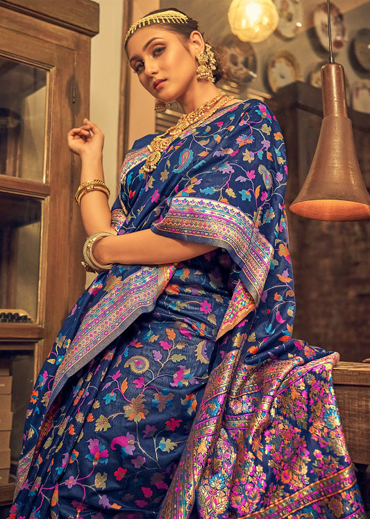 Woman in a blue saree with floral patterns in an indoor setting
