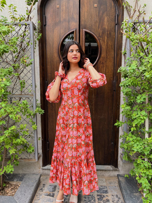 Woman wearing a dark green butta print tiered maxi dress with v-neck and three-quarter sleeves