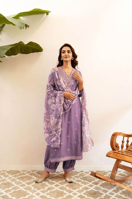 Woman wearing a lavender embroidered kurta suit with a floral print dupatta and salwar pants
Smiling woman wearing a long sleeve lavender kurta with silver embroidery, a light floral print dupatta, and matching salwar pants