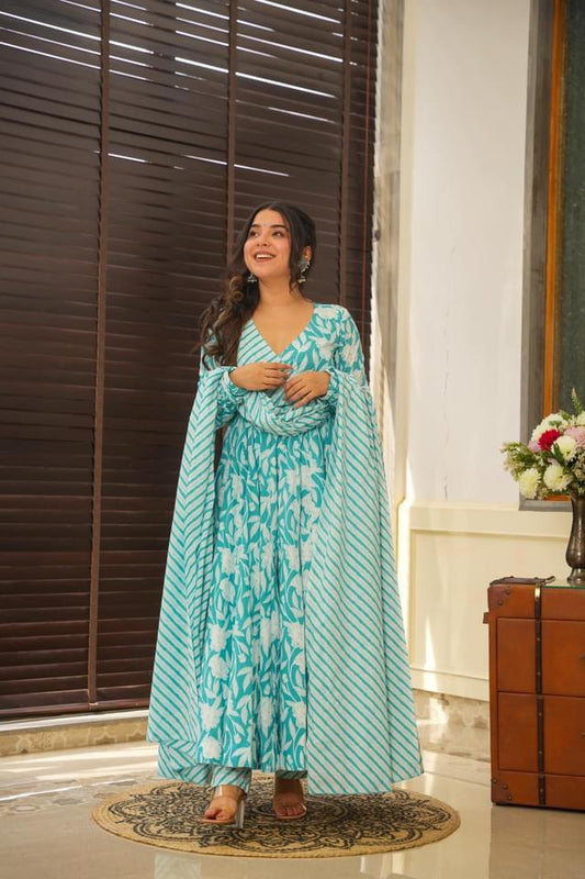 Woman wearing a teal and white printed Anarkali suit with a matching dupatta and churidar pants
Smiling woman wearing a long sleeve teal and white floral or abstract printed Anarkali kurta with a matching dupatta and fitted churidar pants, possibly an Ambraee design

