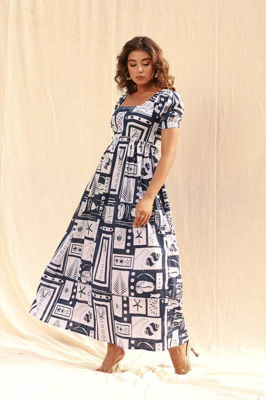 Woman wearing a white and blue nautical print maxi dress with puff sleeves and a square neck
Smiling woman wearing a white maxi dress with a blue geometric and nautical-inspired print, short puff sleeves, and a square neckline