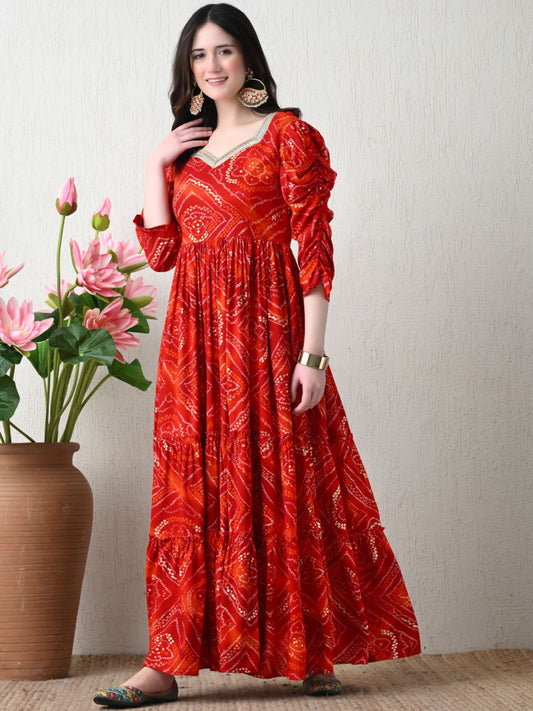 Woman wearing a red bandhani print tiered maxi dress with three-quarter sleeves
Smiling woman wearing a red and orange bandhani patterned tiered long dress with three-quarter gathered sleeves