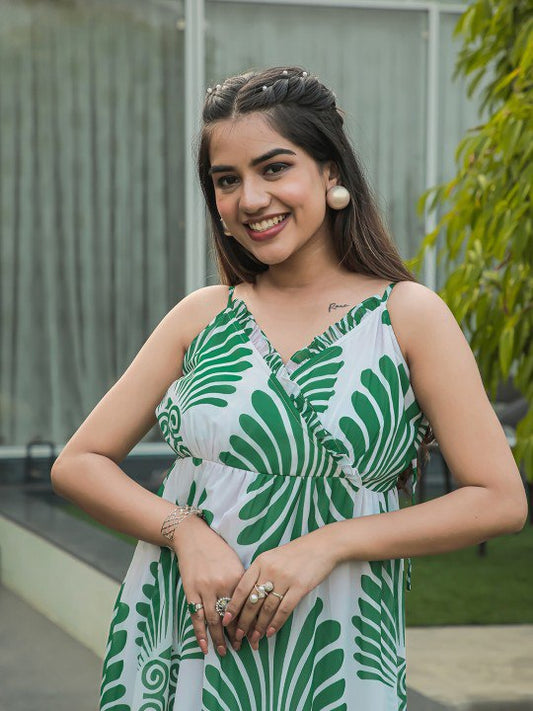 Woman wearing a white and green leaf print tiered maxi dress